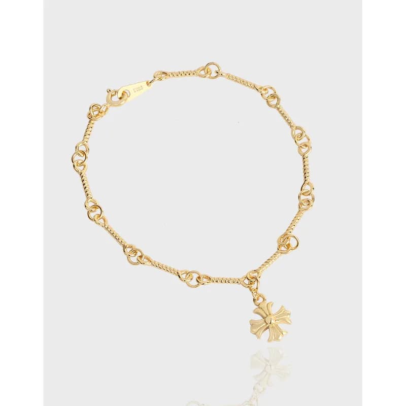 Polished sterling silver bracelet with circular links and a hanging flower charm.
