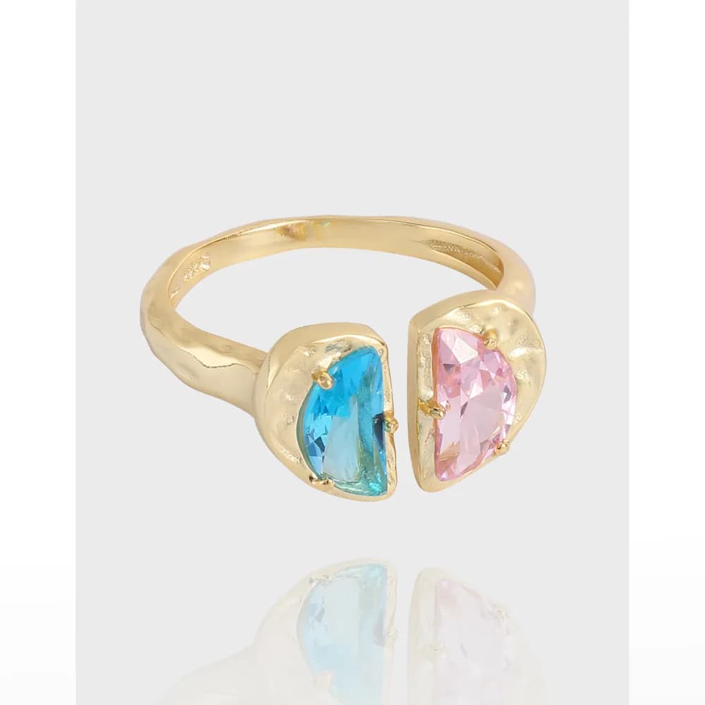 Open-ended ring with two pear-cut stones, blue and pink, set at opposite ends of a curved band.