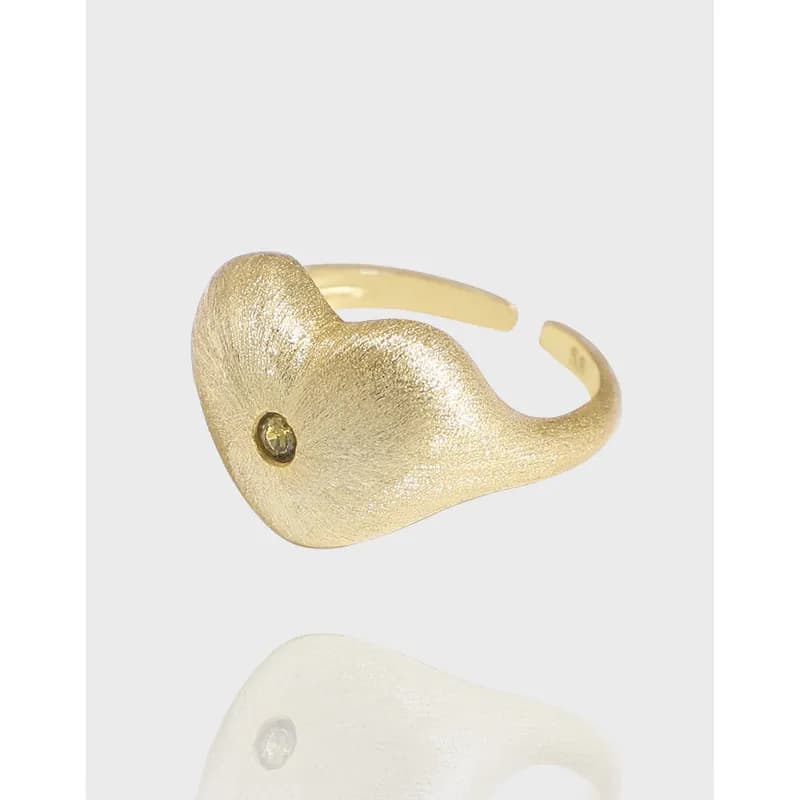 Polished sterling silver heart-shaped ring with a tiny bezel-set stone on an open adjustable band.