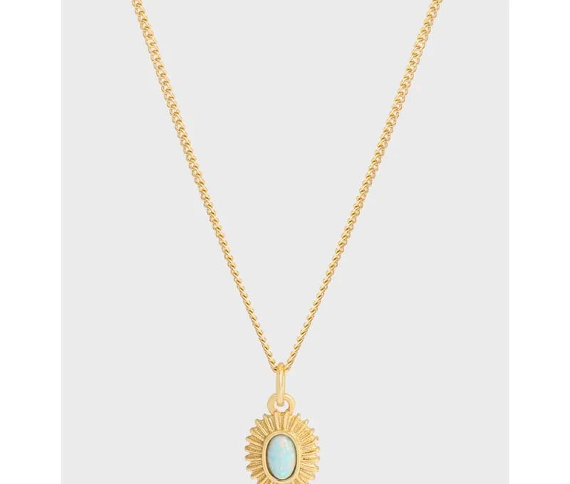 Polished sterling silver necklace with a gold-tone sunburst pendant featuring an oval opal-like stone