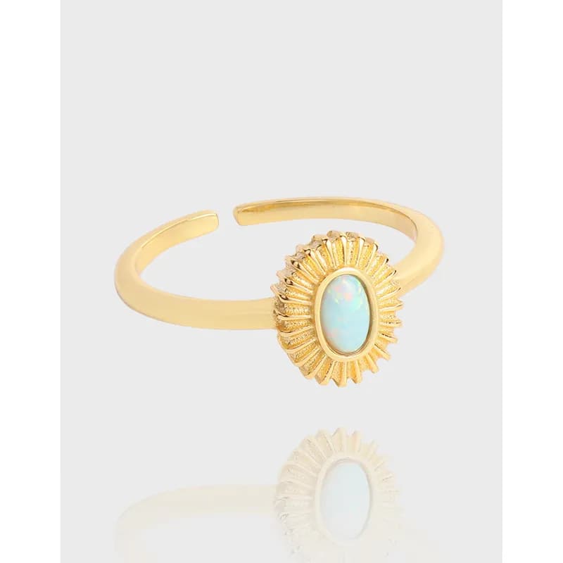 Polished ring with an oval opal cabochon set in a sunburst surround