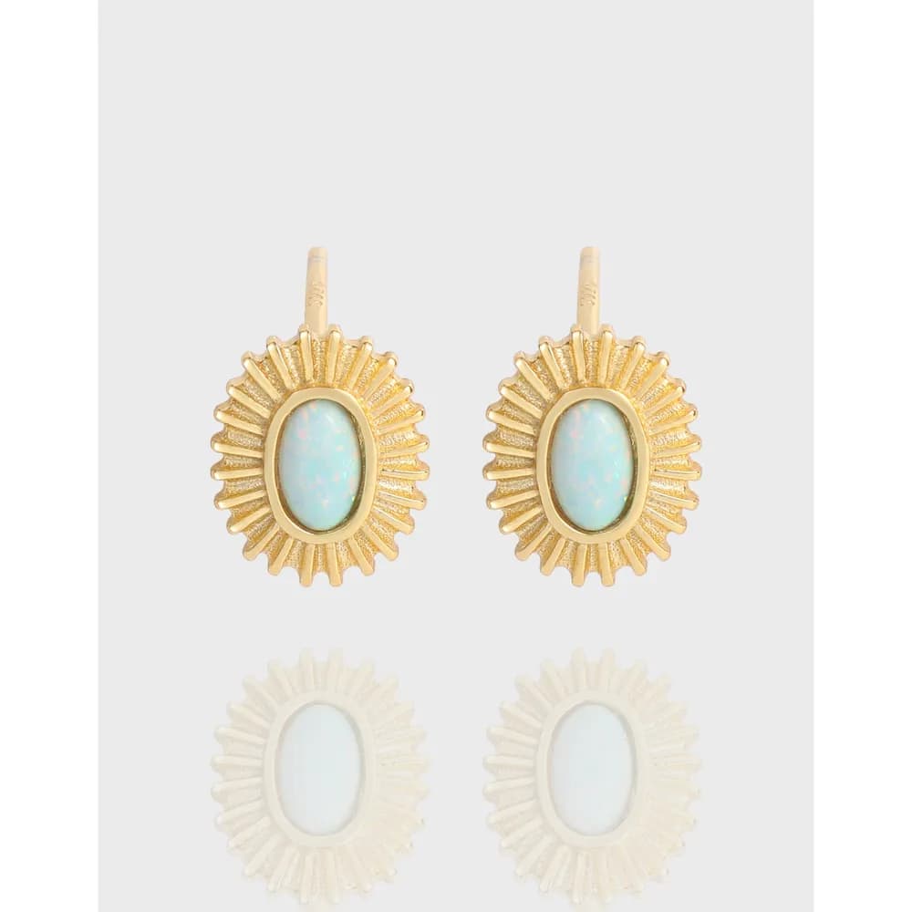 Polished gold-tone sunburst stud earrings with oval opal-like centers