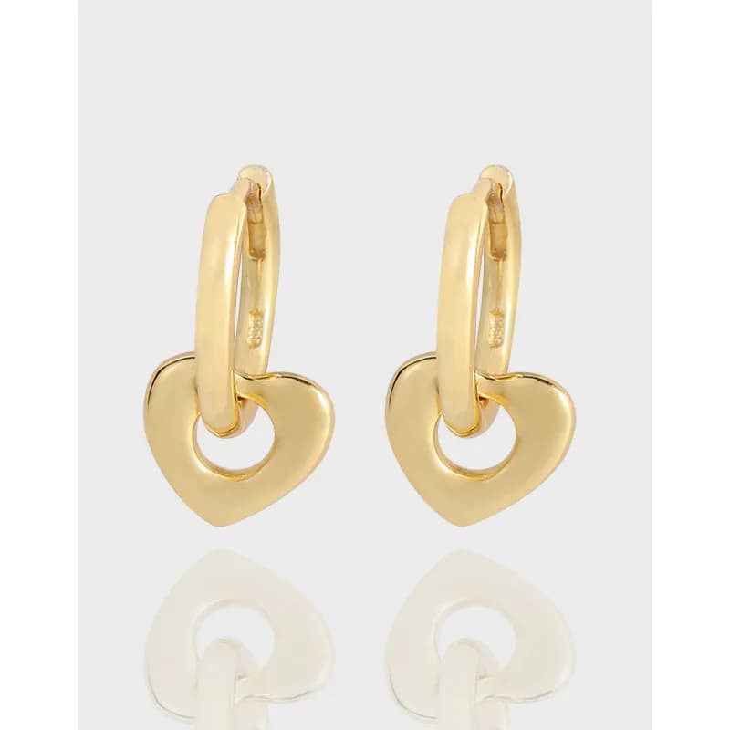 Polished gold-tone heart hoop earrings shown on a white backdrop.
