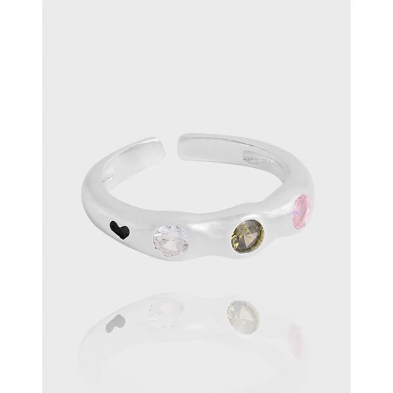 Polished sterling silver open-band ring with four colorful bezel-set stones and a small heart engraving.