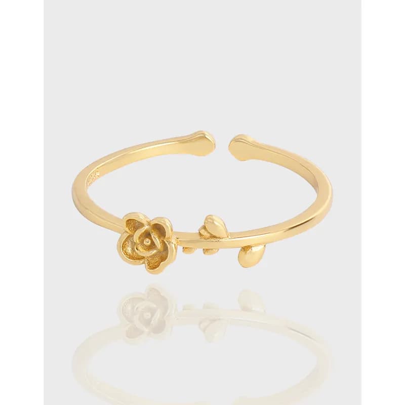 Open floral ring with a small flower on one end and leaf accents on the other, polished silver.