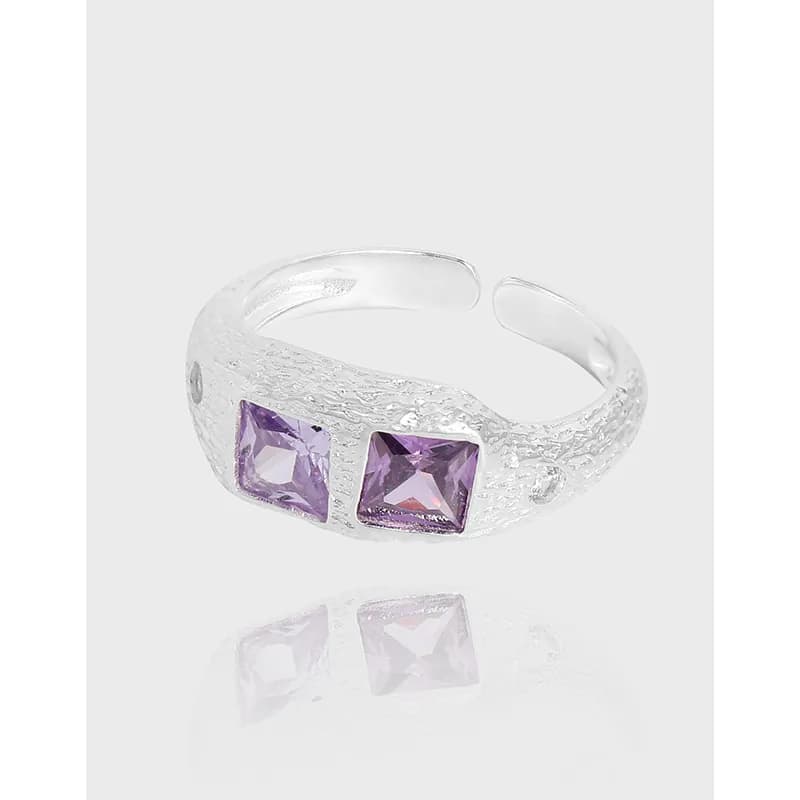 Sterling silver ring with two square purple stones set side by side on a textured band.