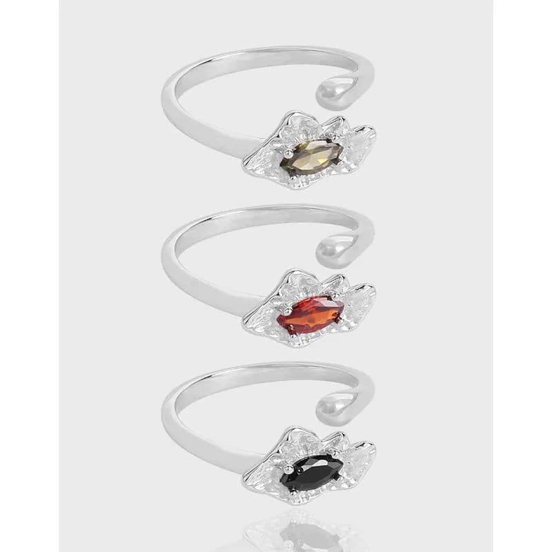Polished sterling silver open-ring with a flower-like setting and marquise gemstone on a pale background.