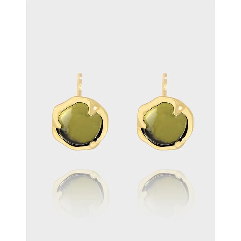 Polished sterling silver stud earrings with olive-green cabochon and sculptural gold-tone bezel