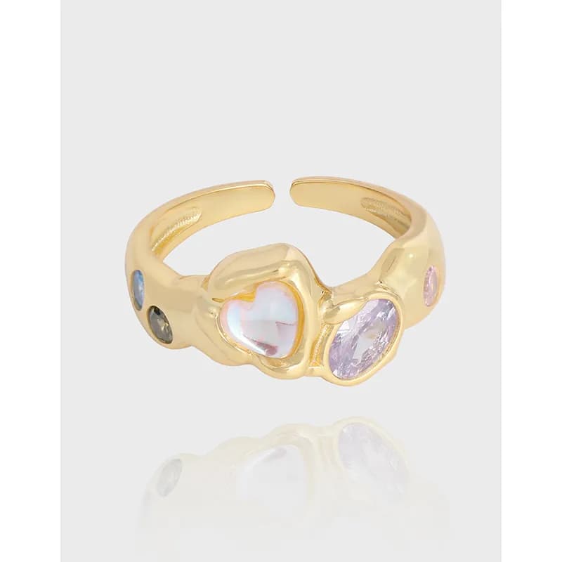 Polished sterling silver ring with a heart-shaped opalescent centerpiece and lavender oval gemstone on a curved band.