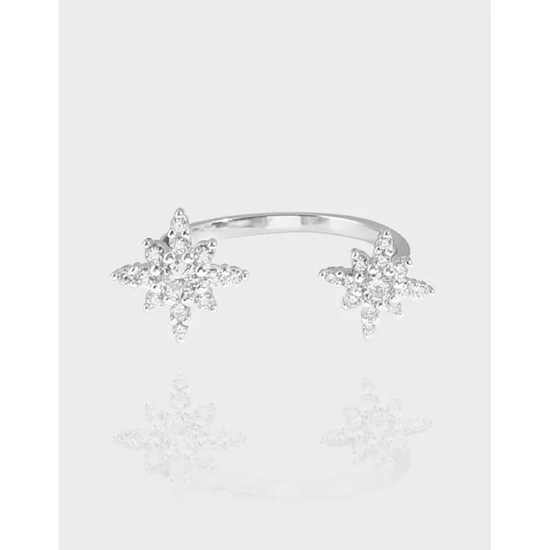 Polished sterling silver ring with two crystal-studded starburst clusters at each end of an open band.