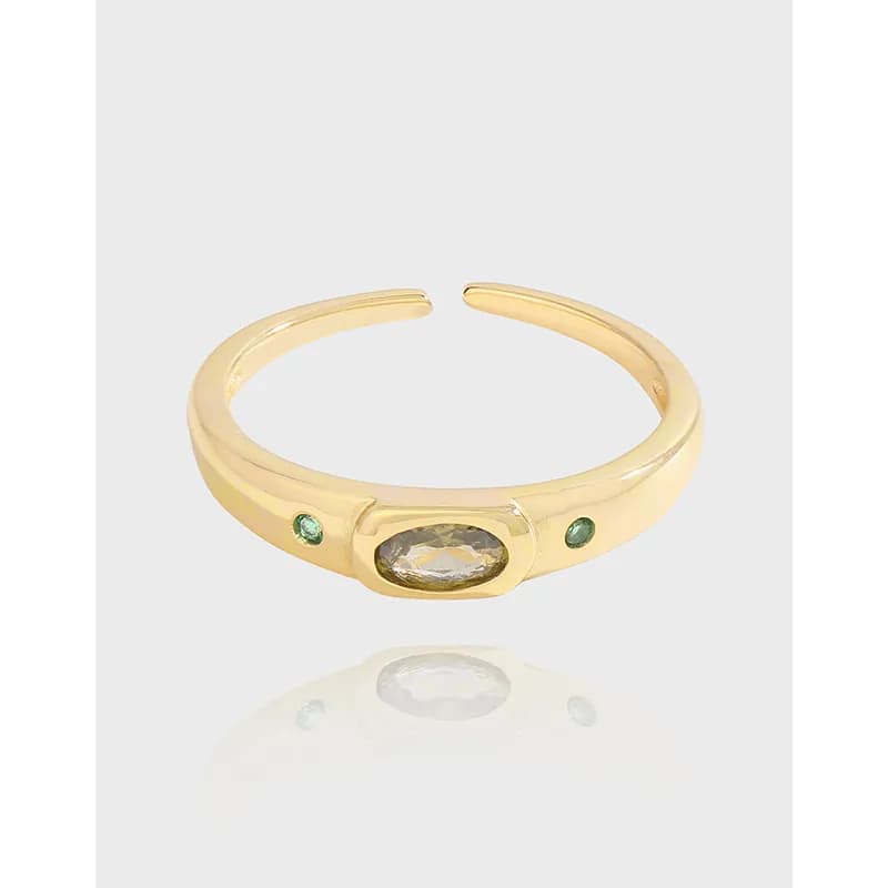 Polished sterling silver ring with an oval bezel stone and two small green side stones