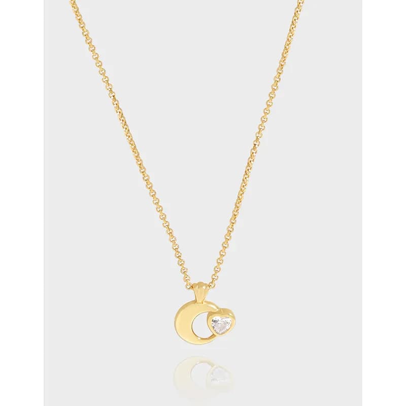 Gold-tone crescent moon pendant with a heart-shaped stone on a delicate chain