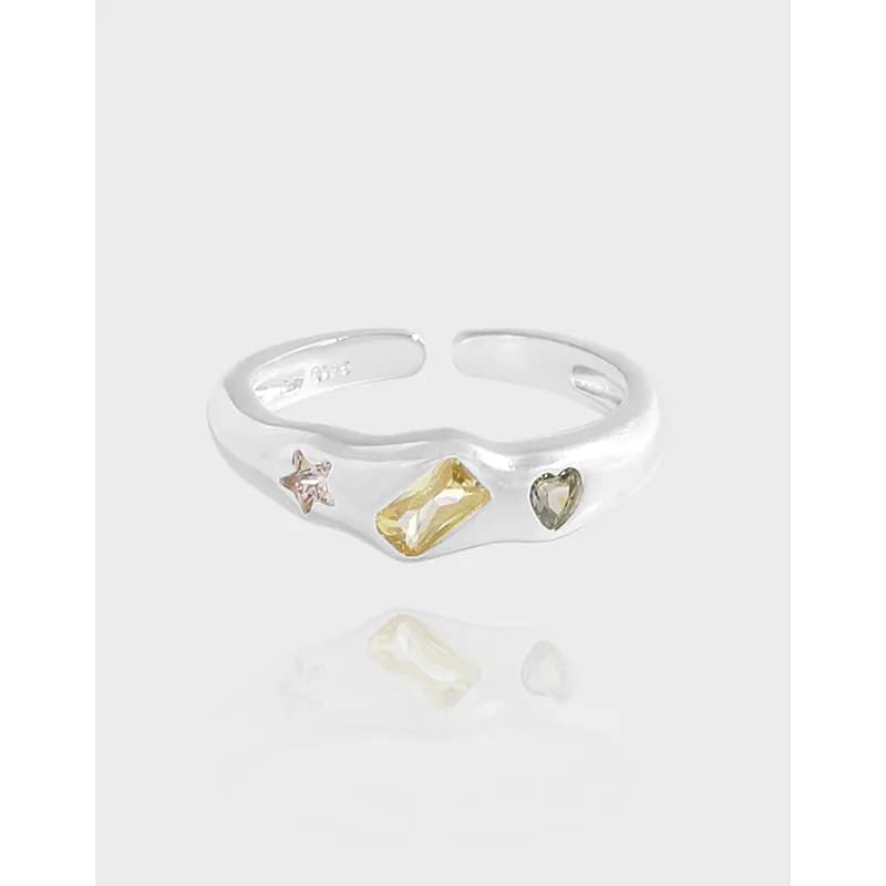 Polished sterling silver open-band ring with three colorful charms: star, yellow rectangular gem, and heart on a white background.