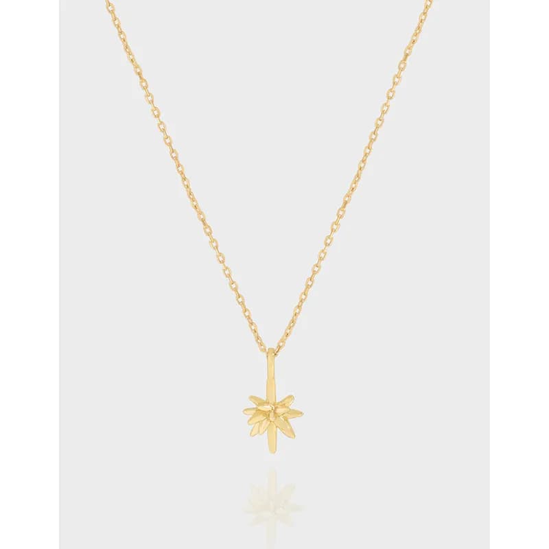 Delicate necklace with a sunburst pendant hanging from a slim chain.