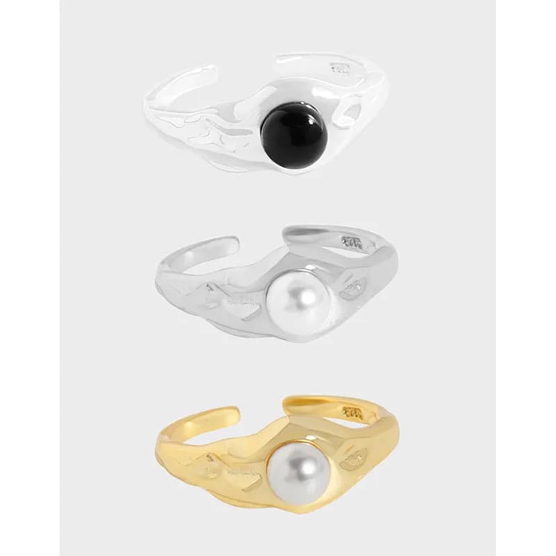 Polished sterling silver ring with a twisting band and a round central pearl or bead