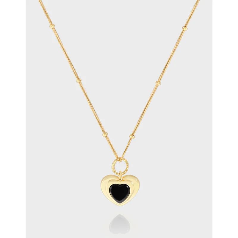 Polished sterling silver necklace with a heart pendant and a black center hanging from a delicate chain.