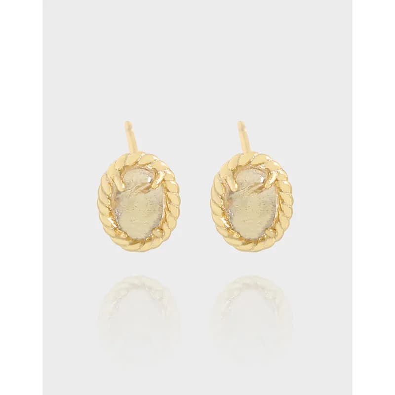 Close-up of polished sterling silver oval stud earrings with a rope-edge surround and small post