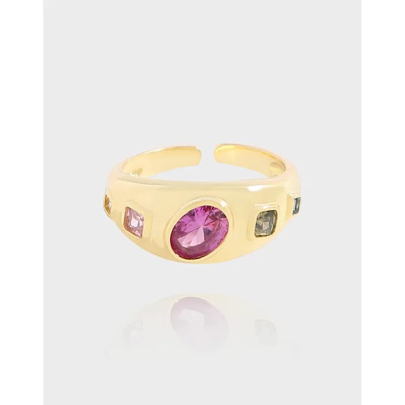 Polished sterling silver ring with a central pink oval gem and smaller side stones in bezel settings.