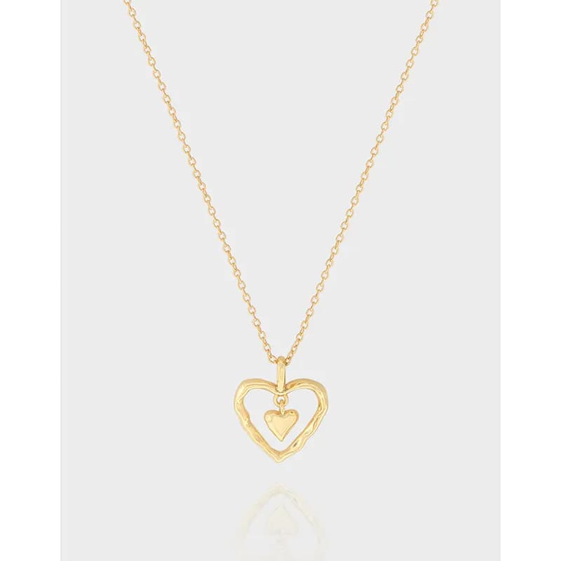 Close-up of a polished sterling silver heart pendant on a fine chain