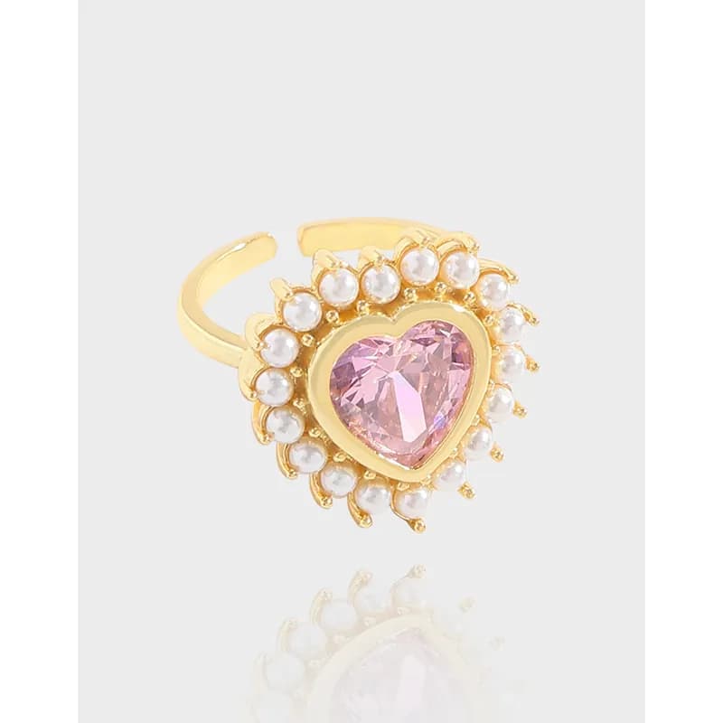 Polished sterling silver ring with a heart pink gem surrounded by a cluster of small white pearls in a sunburst design