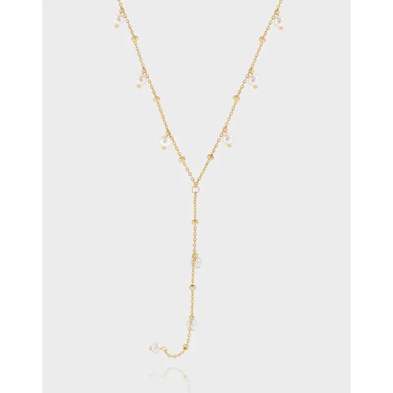 Delicate Y-shaped silver necklace with small white beads along the chain and a longer bead-dotted drop.