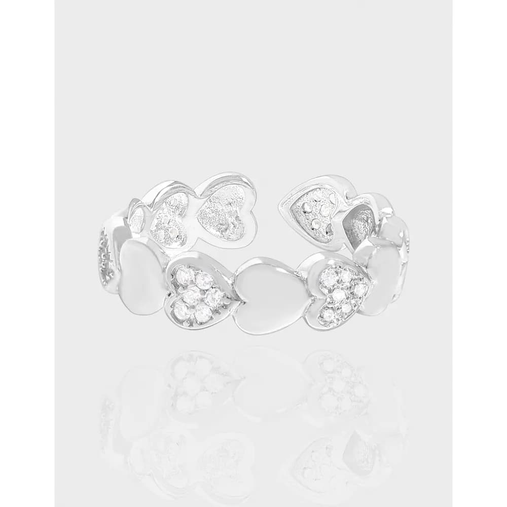 Polished silver heart-link ring with crystal-accented hearts and smooth heart shapes
