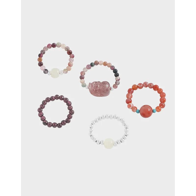 Group of five colorful beaded rings in sterling silver with pastel and coral beads and a few larger focal beads