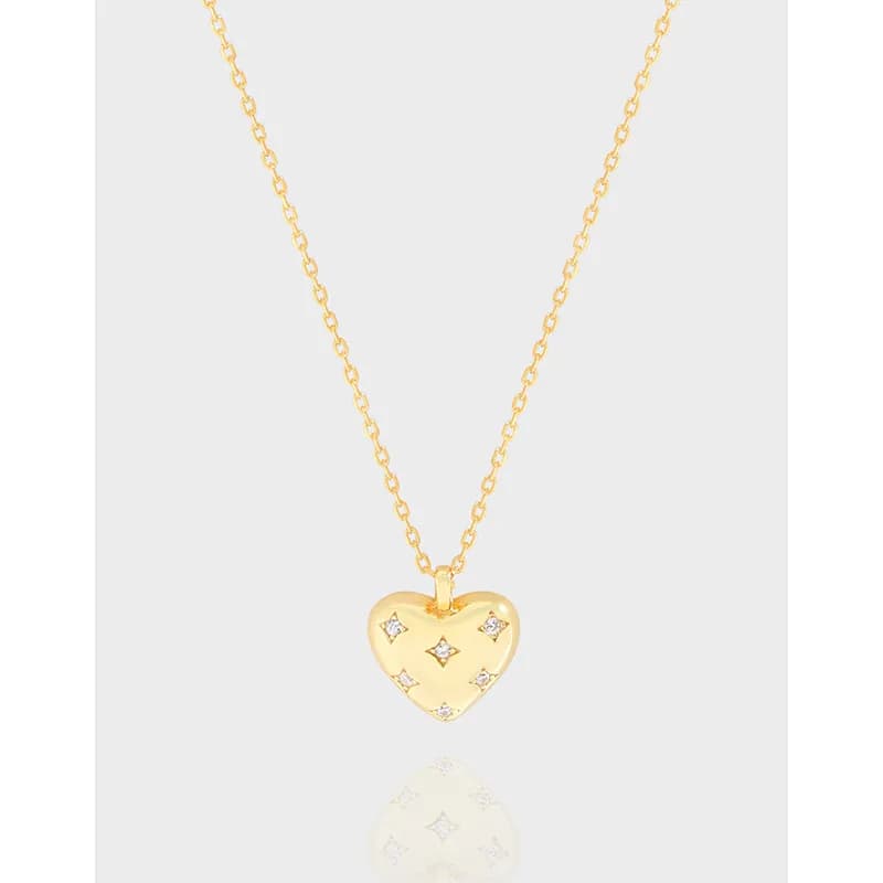 Polished silver chain with a gold-tone heart pendant featuring small clear stones