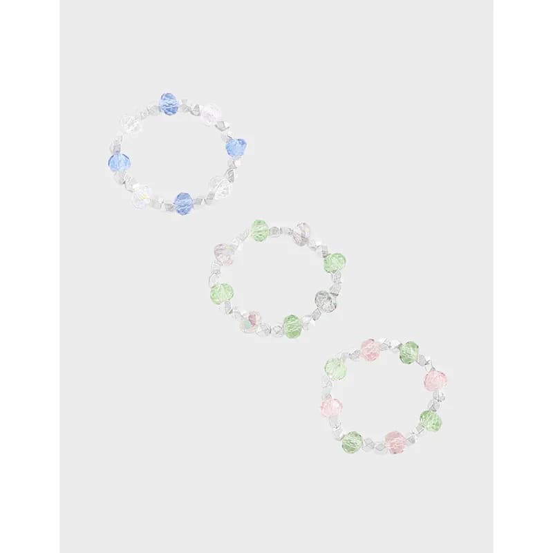 Stretch ring with clear crystals and pastel blue, green, and pink beads on a polished silver band.