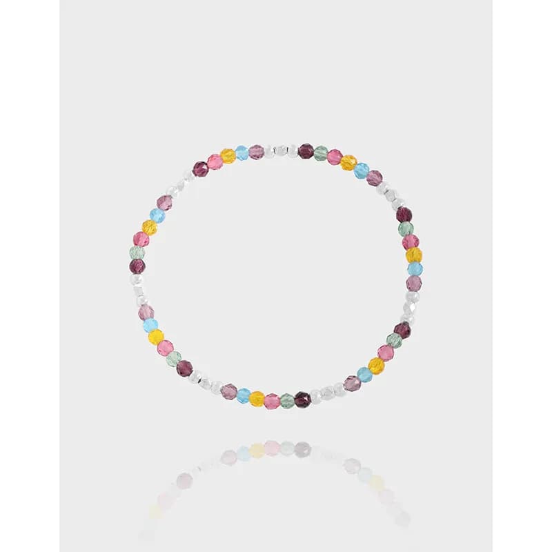 Polished sterling silver bracelet featuring multicolored faceted beads and clear spacers in a circular arrangement.
