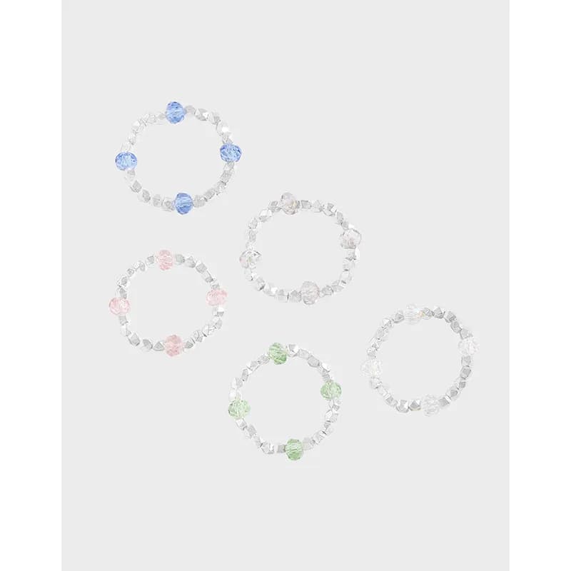 Beaded circle rings in sterling silver with pastel colored beads arranged around a faceted bead band.
