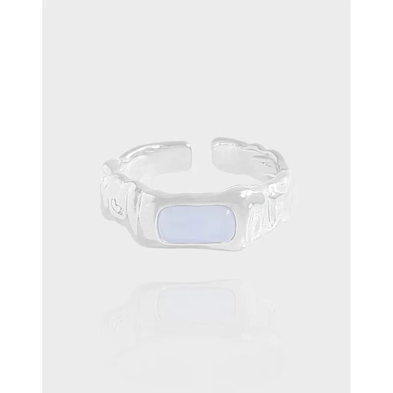 A polished sterling silver ring with an elongated rectangular pale blue cabochon bezel setting