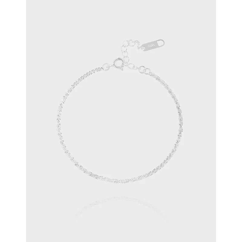 Delicate sterling silver pavé bracelet with a short extender chain and clasp on a light background.