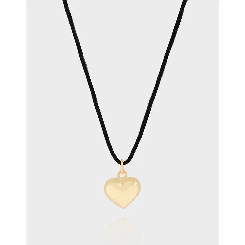 Black braided cord necklace with a polished heart pendant.