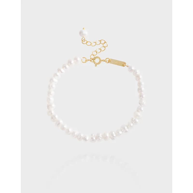Close-up of a pearl bead bracelet with a gold-tone extender chain and clasp.