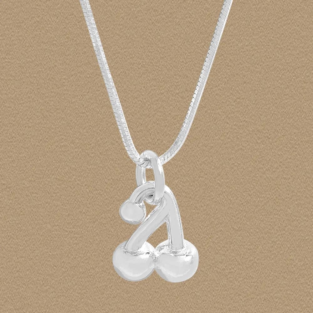 Polished sterling silver cherry pendant on a delicate chain against a warm background.