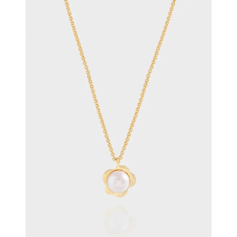 Delicate sterling silver necklace with a pearl pendant in a flower-shaped setting on a thin chain.