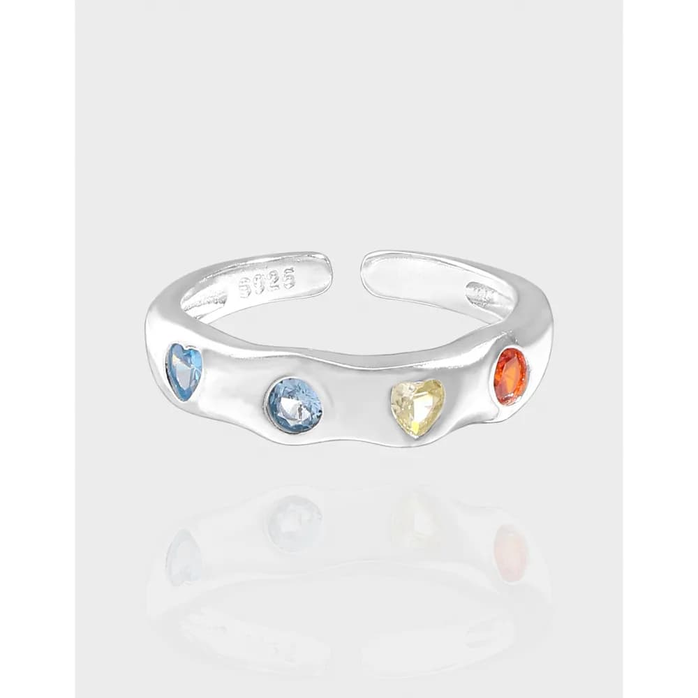 Polished sterling silver ring with four bezel-set colorful stones along a curved band.