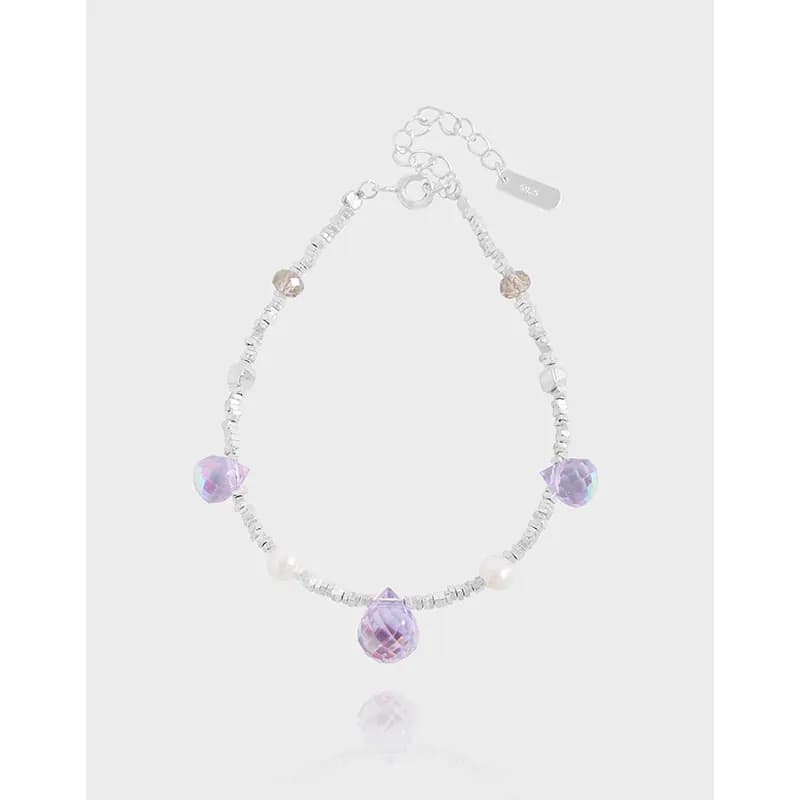 Sterling silver beaded bracelet with lilac teardrop crystals and pearls on a light background.