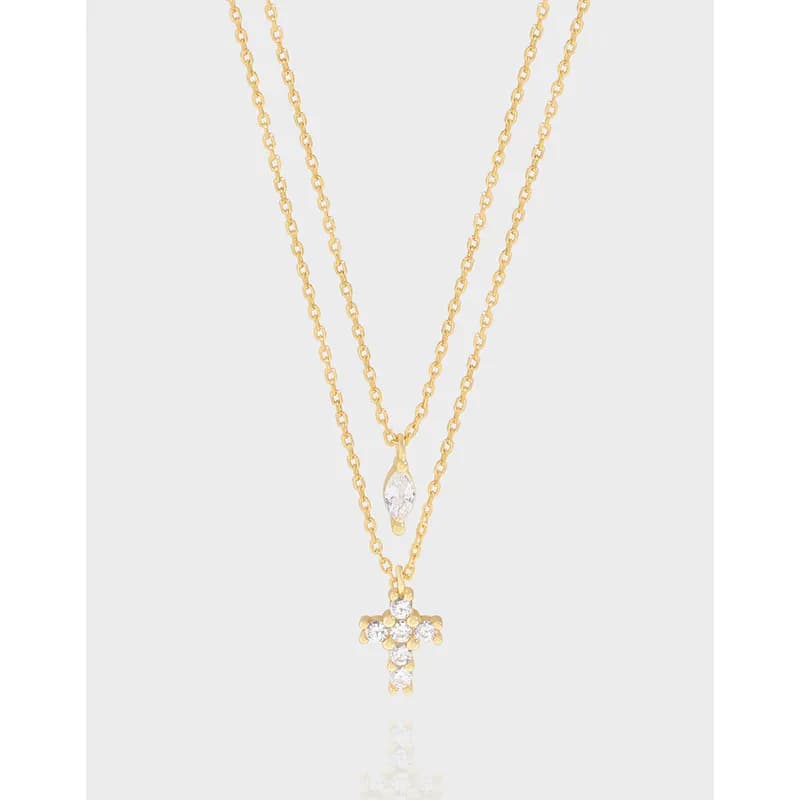 Two-layer gold-tone chain necklace with teardrop crystal and crystal-cross pendant on a light background.