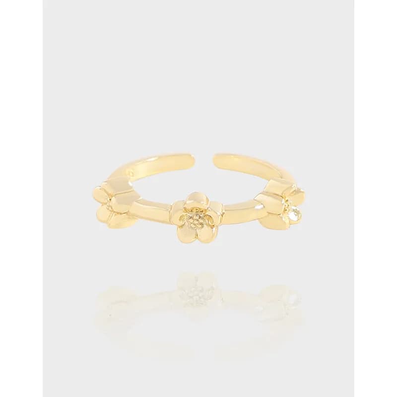 Gold-tone floral ring featuring three flower motifs along an open band.