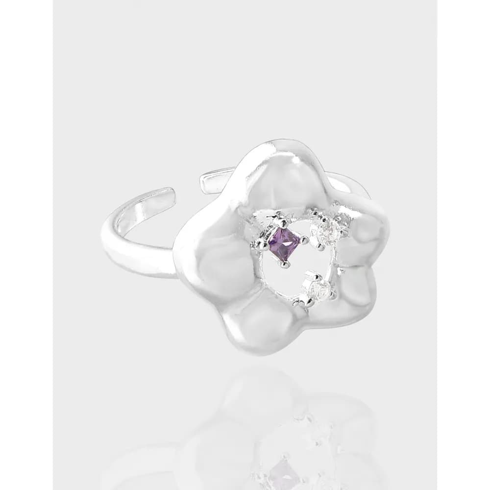 Polished sterling silver flower-shaped ring with a purple gemstone centerpiece and small surrounding stones.