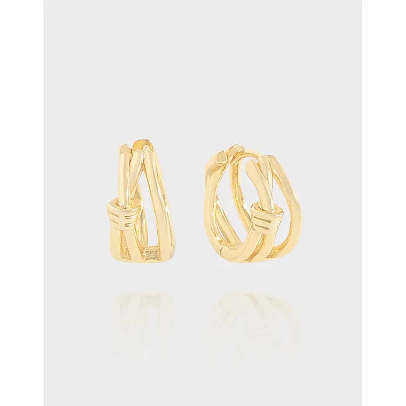 Polished sterling silver interwoven hoop earrings on a light background.