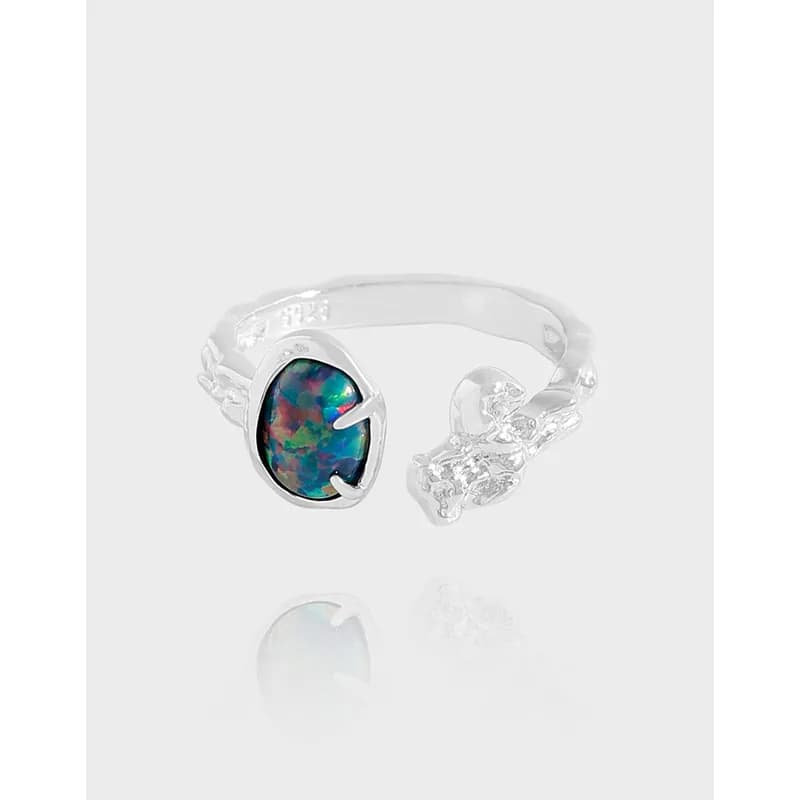 Open silver ring with a multicolor opal centerpiece in a bezel setting and a decorative silver end on the opposite side.