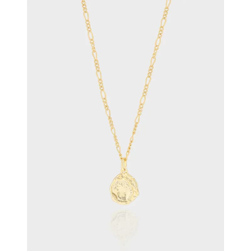 Close-up of a polished sterling silver chain necklace with a hammered coin pendant hanging at the center.