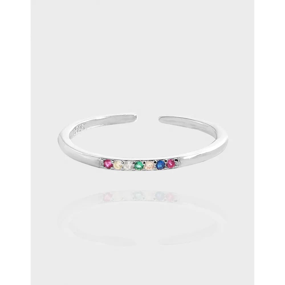 Polished sterling silver open ring with a row of small colorful gemstones along the top edge.