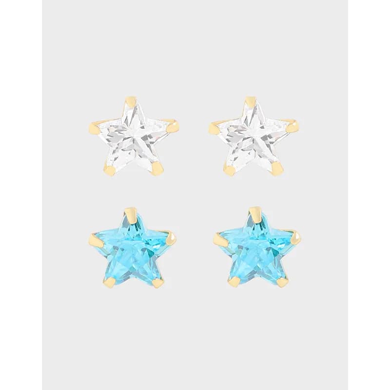 Star-shaped stud earrings in clear and blue tones with gold prong settings on a polished silver base.