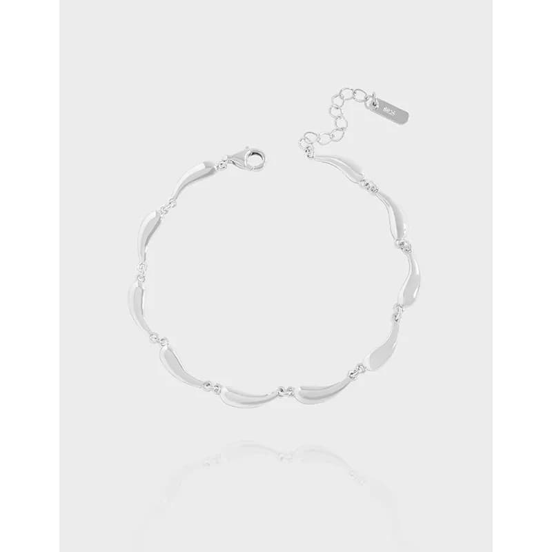 Polished curved bar links bracelet with lobster clasp and extender chain on a light background.