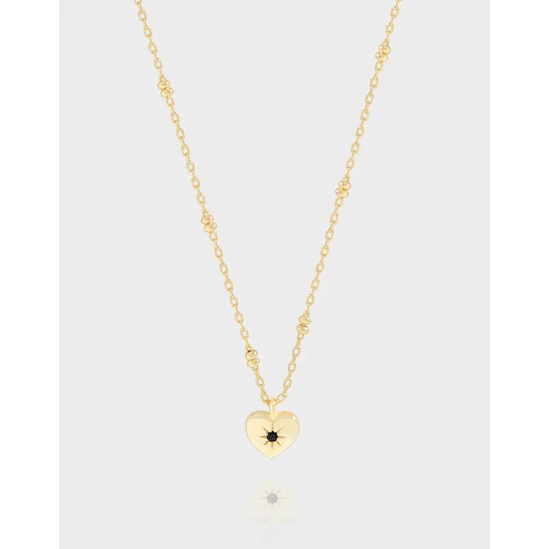 Polished sterling silver heart pendant on a delicate chain against a light background.