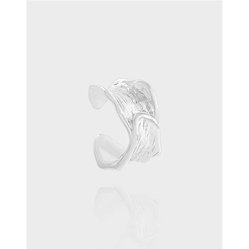 Polished sterling silver ear cuff with a curved, textured surface that wraps around the ear